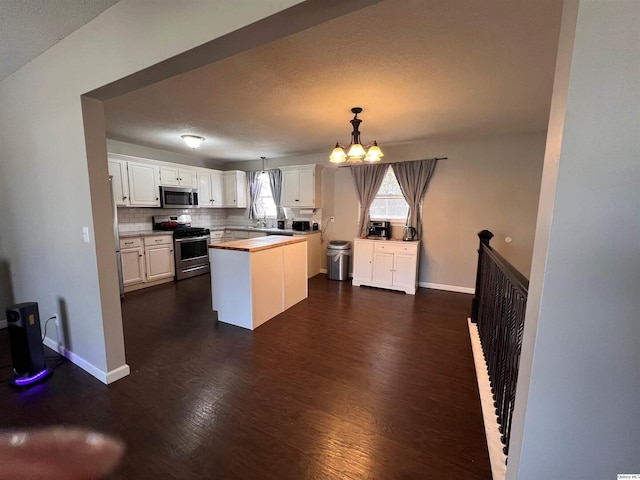 2433 Cedar Creek Ct, Quincy, IL 62305 - kitchen featuring appliances with stainless steel finishes, white cabinets, a chandelier, hanging light fixtures, and a center island
