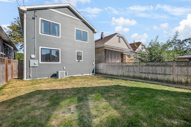 back of house featuring a lawn and cooling unit