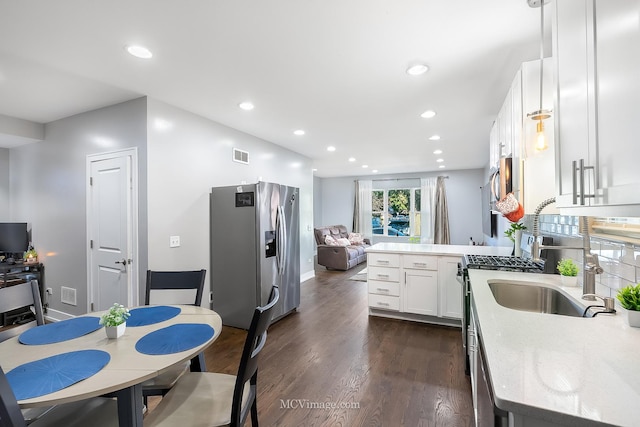 kitchen featuring kitchen peninsula, stainless steel refrigerator with ice dispenser, dark wood-type flooring, sink, and white cabinets