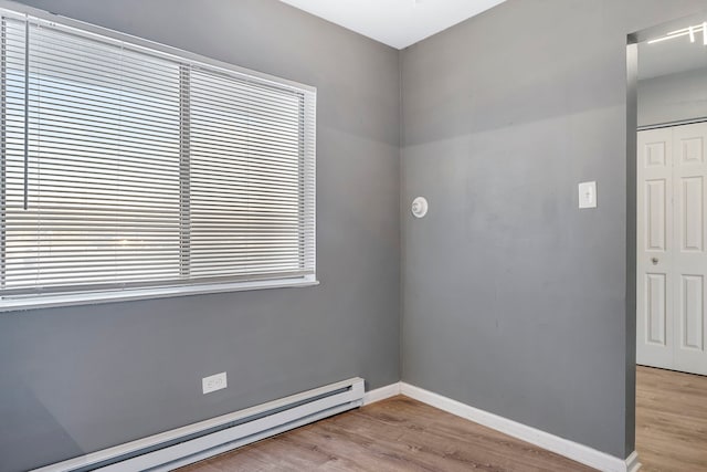 spare room featuring light hardwood / wood-style floors and a baseboard heating unit