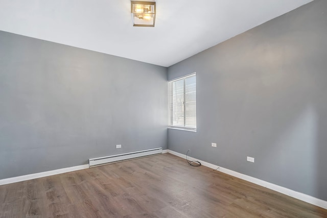 empty room with hardwood / wood-style floors and baseboard heating