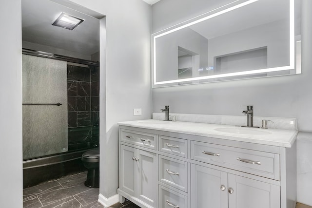 bathroom with vanity, toilet, and a shower with door