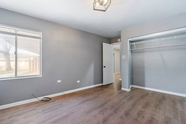 unfurnished bedroom with hardwood / wood-style flooring and a closet