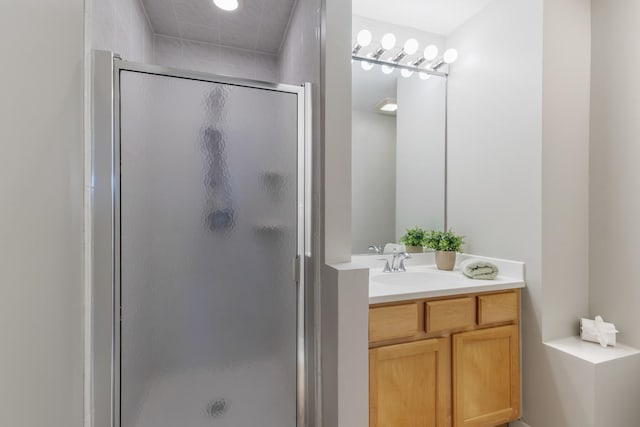 bathroom featuring a shower with door and vanity