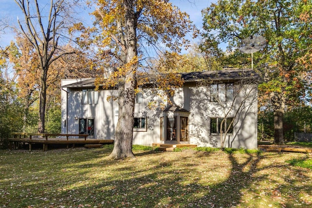 rear view of house featuring a lawn and a wooden deck