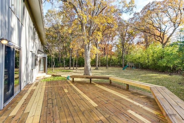 wooden deck featuring a playground and a yard