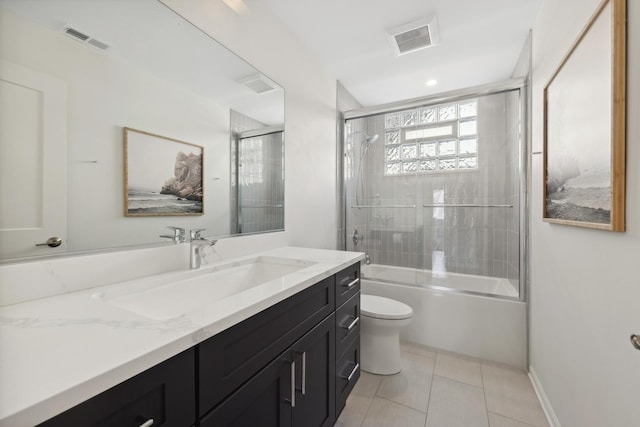 full bathroom featuring combined bath / shower with glass door, tile patterned floors, vanity, and toilet