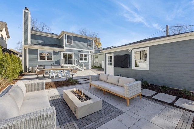 back of house with a patio and an outdoor living space with a fire pit