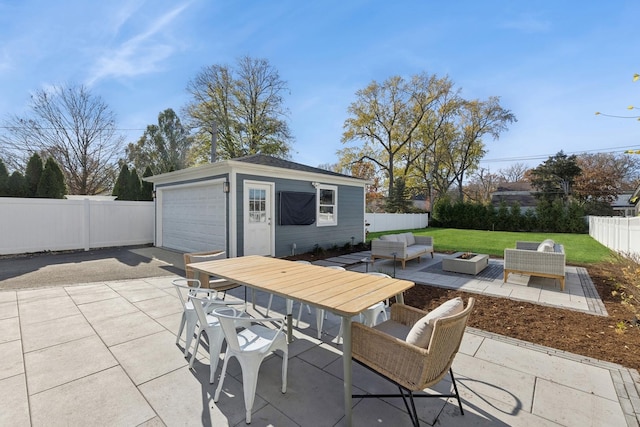 view of patio with outdoor lounge area, an outbuilding, and a garage