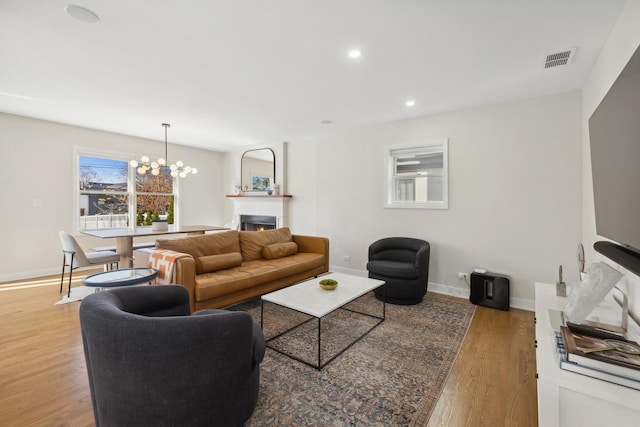 living room with hardwood / wood-style floors and a notable chandelier