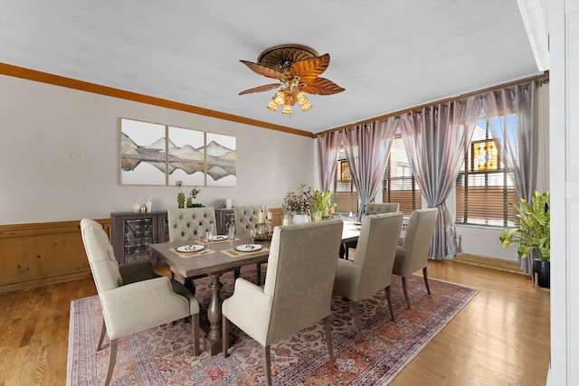 dining room with ceiling fan, crown molding, and light wood-type flooring