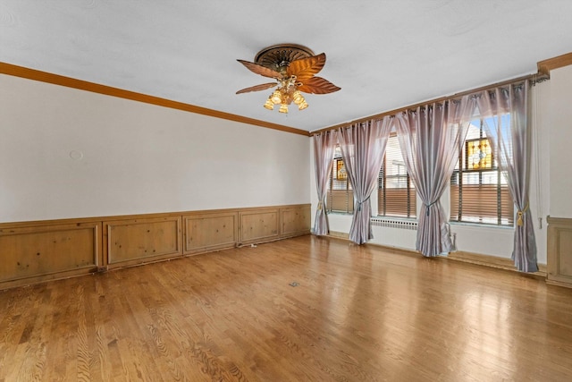 spare room with crown molding, ceiling fan, and light hardwood / wood-style floors