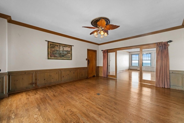 empty room featuring light hardwood / wood-style flooring, ceiling fan, and ornamental molding