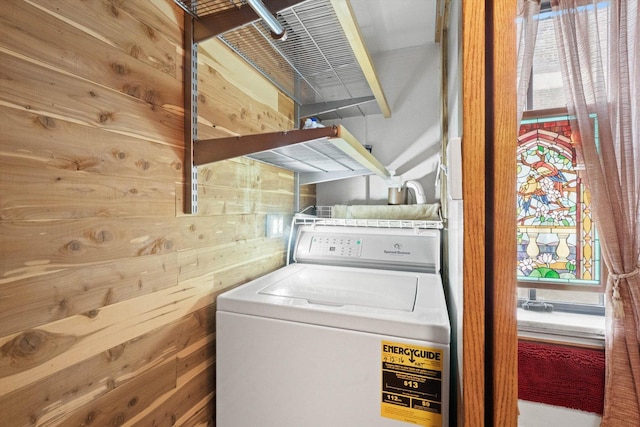 clothes washing area featuring washer / clothes dryer and wooden walls