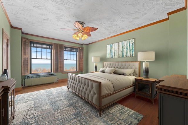 bedroom featuring ceiling fan, wood-type flooring, radiator heating unit, and ornamental molding