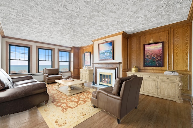 living room featuring dark hardwood / wood-style flooring, crown molding, a fireplace, and plenty of natural light