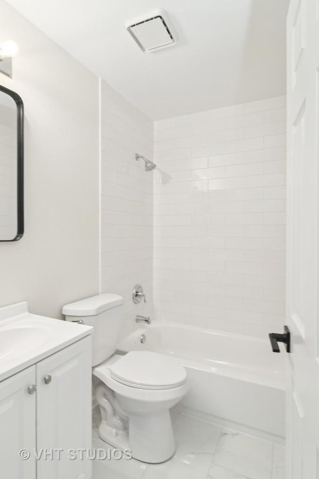 full bathroom featuring toilet, tiled shower / bath, and vanity