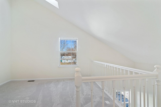 bonus room with carpet flooring, plenty of natural light, and vaulted ceiling with skylight