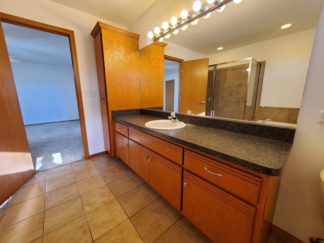 bathroom with vanity, a shower with door, and tile patterned flooring