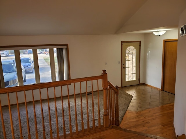 entryway with lofted ceiling and light tile patterned flooring