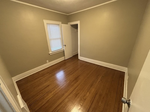 unfurnished room featuring dark hardwood / wood-style floors and ornamental molding