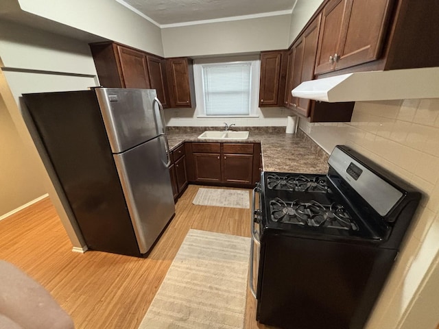 kitchen featuring crown molding, sink, light hardwood / wood-style floors, black range with gas cooktop, and stainless steel refrigerator