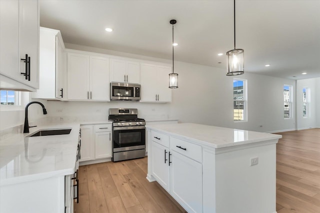 kitchen with sink, a center island, white cabinets, and appliances with stainless steel finishes