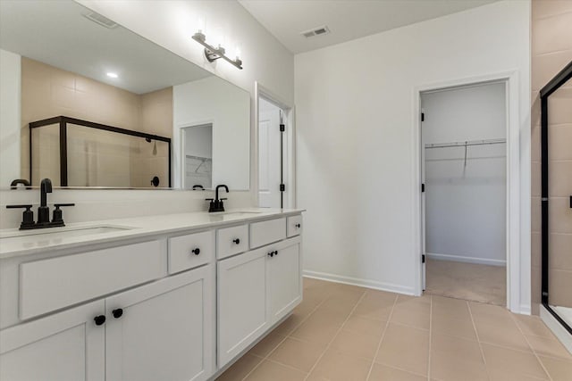 bathroom with tile patterned flooring, vanity, and a shower with shower door