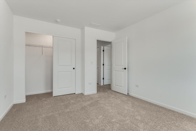 unfurnished bedroom with light carpet and a closet