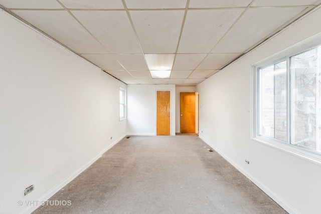 spare room with a drop ceiling and carpet