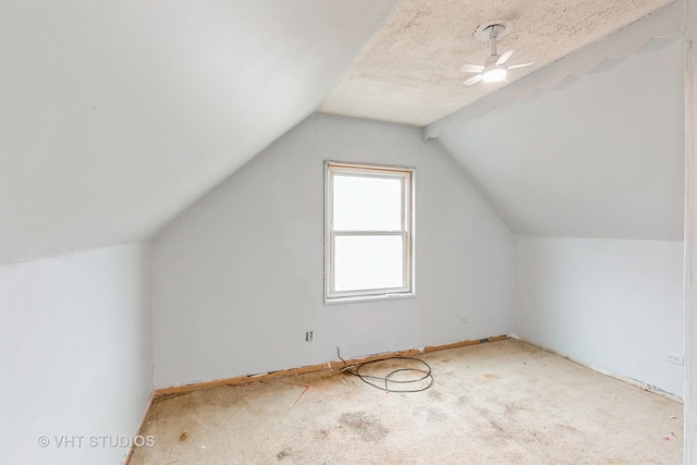 additional living space with a textured ceiling, ceiling fan, and lofted ceiling