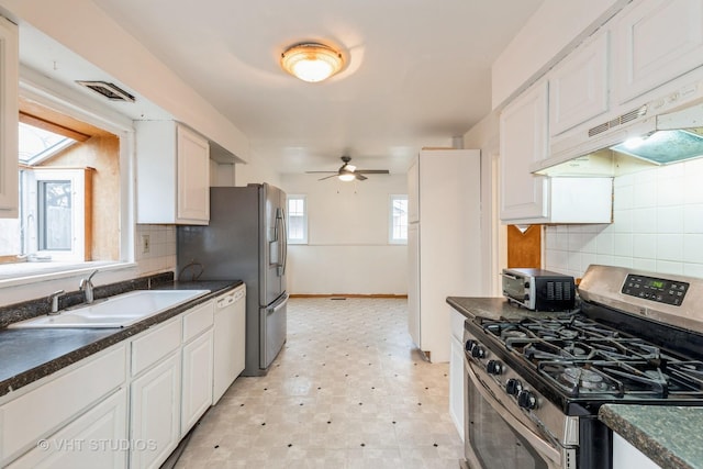 kitchen with tasteful backsplash, sink, white cabinets, and stainless steel appliances