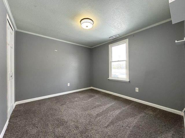 carpeted empty room featuring ornamental molding and a textured ceiling