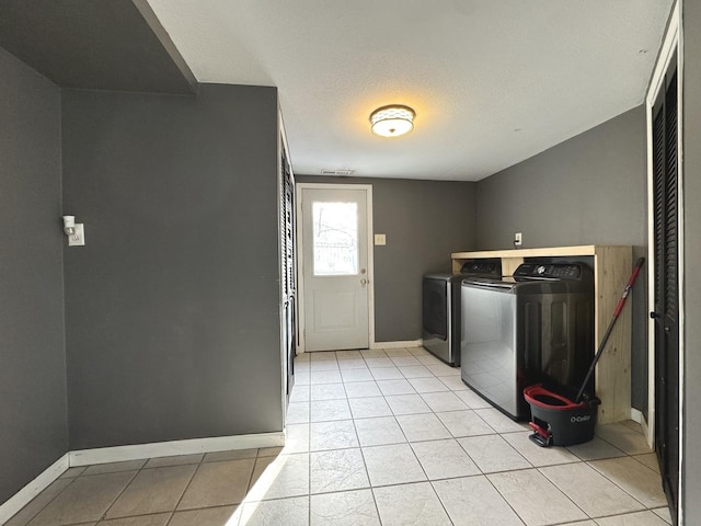 washroom featuring light tile patterned flooring and washer and clothes dryer