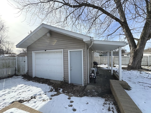 snow covered garage with a carport