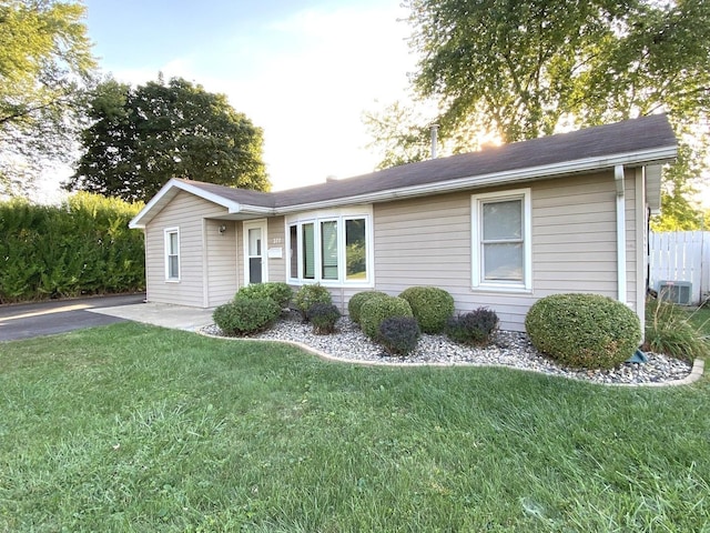 single story home with central air condition unit and a front lawn