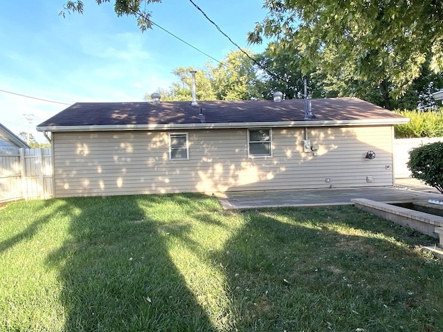 back of house with a patio area and a lawn