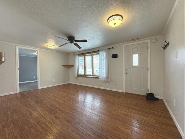 foyer entrance with ornamental molding, dark wood-type flooring, a textured ceiling, and ceiling fan