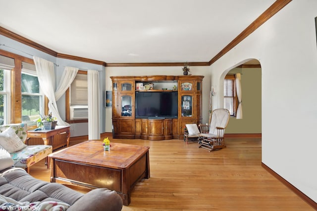 living room with plenty of natural light, cooling unit, light hardwood / wood-style floors, and ornamental molding