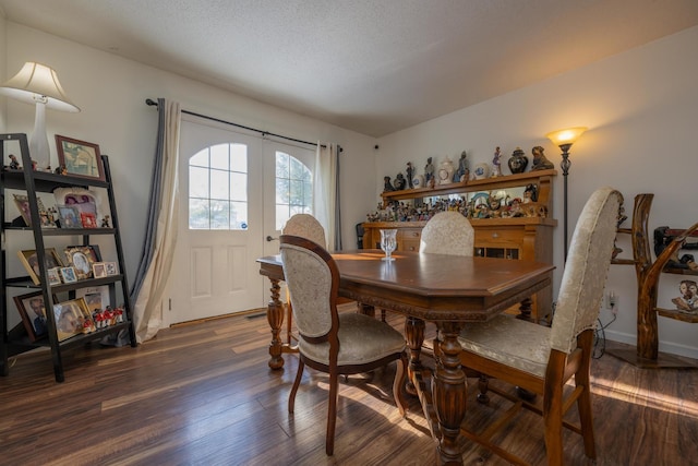 dining area featuring a textured ceiling, dark hardwood / wood-style flooring, and french doors