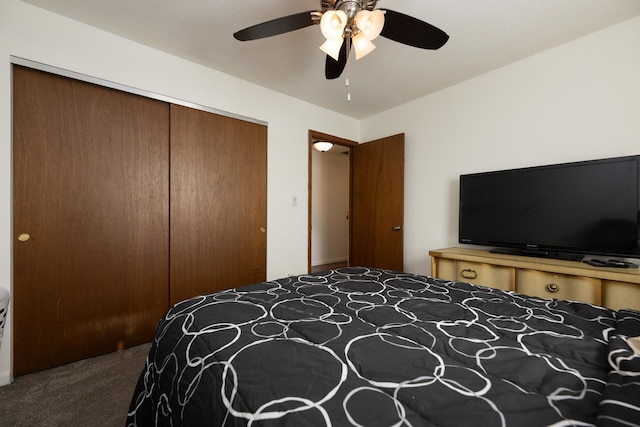 bedroom featuring dark colored carpet, a closet, and ceiling fan