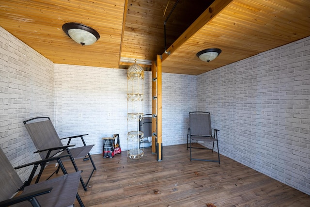 unfurnished room with wooden ceiling, brick wall, and dark hardwood / wood-style flooring