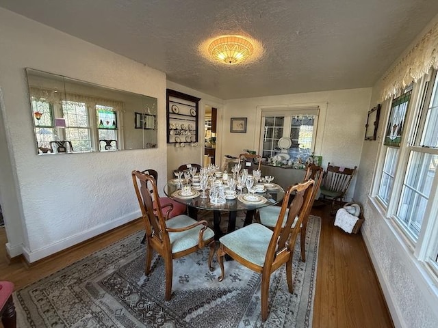 dining room with a textured ceiling and dark wood-type flooring