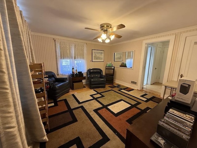 interior space with ceiling fan and ornamental molding