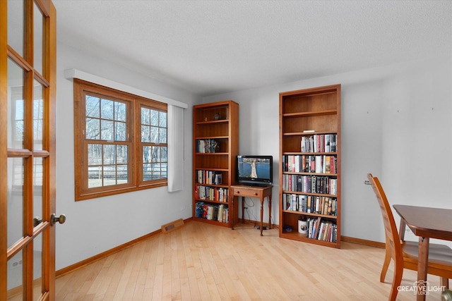 interior space featuring light hardwood / wood-style floors and a textured ceiling