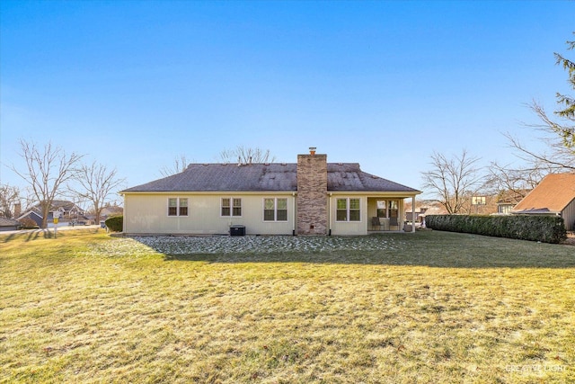 rear view of property featuring a yard and cooling unit