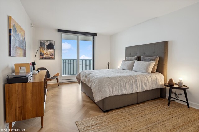 bedroom with a baseboard heating unit, floor to ceiling windows, access to outside, and light parquet flooring