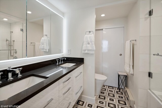 bathroom with vanity, toilet, and a shower with shower door