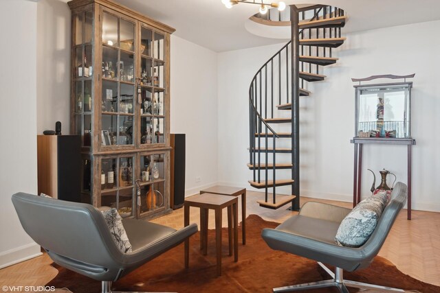 sitting room with parquet floors and an inviting chandelier