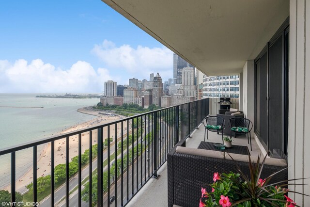 balcony featuring a water view and a beach view